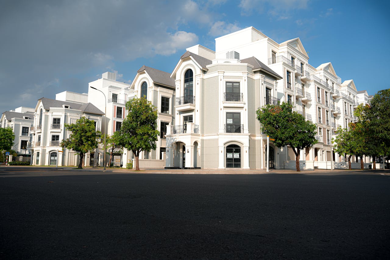 A modern apartment complex with classic architectural design under a bright blue sky.